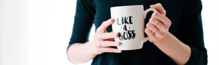 woman holding mug with like a boss writing