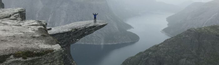 man on cliff overcoming challenges