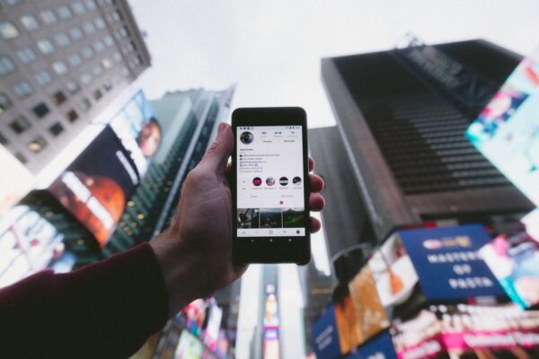 Hand holding phone with social media on display